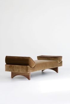 a brown couch sitting on top of a white floor next to a wooden frame chair