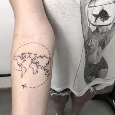 a person with a tattoo on their arm and the world map behind them is shown