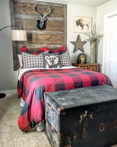 a bedroom with a bed, chest and headboard made out of wooden planks