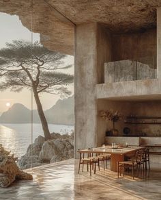 a dining room and living room with a view of the water at sunset or dawn