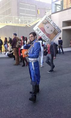 a man dressed in blue is holding a sign