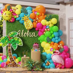 a tropical themed birthday party with balloons, pineapples and flamingos on the wall