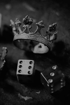 two dices and a crown sitting on top of a table