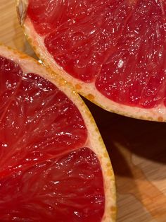 two grapefruits cut in half on a cutting board