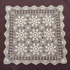 a white crocheted doily on a brown background