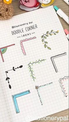 an open notebook with doodle corner images on it next to markers, pens and a teddy bear