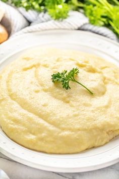 a white plate topped with mashed potatoes and garnished with green parsley