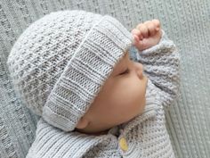 a baby wearing a knitted hat and sweater