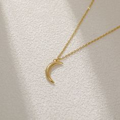 Adorn yourself with celestial grace wearing the Petite Lunar Crescent Pendant. Crafted delicately, this dainty necklace features a miniature crescent moon, a symbol of mystique and intuition. Embrace the allure of the night sky with this elegant accessory, lending a touch of cosmic charm to your style. 18k Gold Plated Stainless Steel Pendant Size - 15mm x 10mm Chain length - 45cm Chain Style - Classic chain Tarnish free / Water resistant 💧 Dainty Crescent Moon Charm Necklace, Delicate Crescent Moon Charm Necklace, Elegant Sterling Silver Crescent Charm Necklace, Elegant Moon Shape Clavicle Chain Necklace, Dainty Half Moon Necklace With Moon Charm, Dainty Necklace With Half Moon Charm, Dainty Crescent Necklace With Delicate Chain, Minimalist Crescent Moon Phase Charm Necklace, Minimalist Crescent Clavicle Chain Charm Necklace