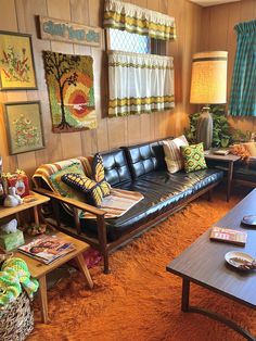 a living room filled with furniture and pictures on the wall next to a table topped with a lamp