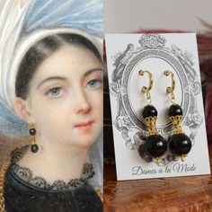 "These earrings are based off of this early 19th Century portrait I came across in my research.  Unfortunately I haven't been able to find any details about it, but it's probably from the 1820s-1830s.  Her lovely, bold black and gold earrings are so striking! My version is made with black glass beads and rich gold-plated filigree elements.  They have lots of fun dangle and movement! These measure about 2\" long, including the clasp.  Shown here on hoop findings, but also available as a leverback Regency Era Jewelry, 1800s Jewelry, Regency Jewelry, Black And Gold Earrings, Pearl Teardrop Earrings, 19th Century Portraits, Victorian Accessories, Gold Filigree Earrings, Jewelry Victorian