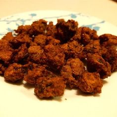 a white plate topped with fried food on top of a table