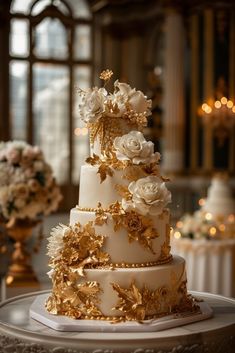 a three tiered wedding cake with white and gold flowers