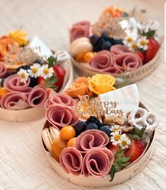 two baskets filled with fruit and vegetables on top of a white cloth covered tablecloth