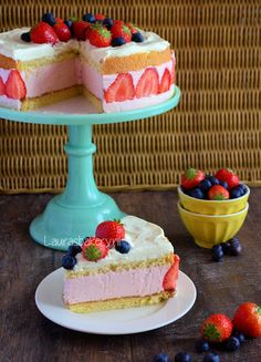 a piece of cake on a plate with berries and blueberries next to the cake