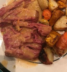 a white plate topped with meat, potatoes and carrots