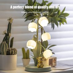 a lamp that is sitting on top of a table next to a potted plant