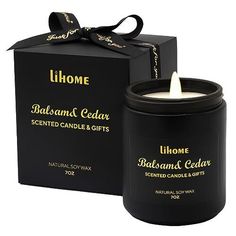 a candle in a black box with a ribbon around it and the lid is open