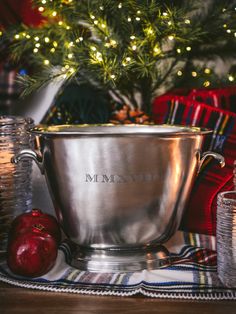 a silver bowl sitting on top of a table next to a christmas tree and other decorations