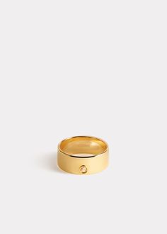 a gold ring with a small diamond on the inside, sitting in front of a white background