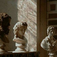 three busturines sitting on top of marble pedestals in a room with sunlight coming through the window