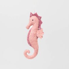 a pink sea horse ornament hanging from a string