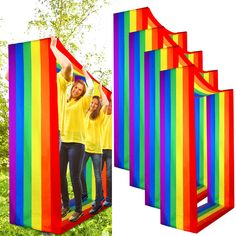 three people standing in front of a rainbow colored structure