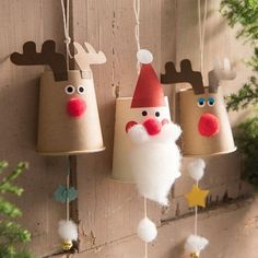 three christmas decorations hanging from the side of a wooden wall with santa claus and reindeer faces