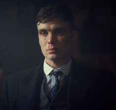 a man wearing a suit and tie in the dark