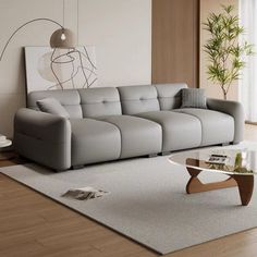 a living room with a couch, coffee table and plant in the corner on the floor