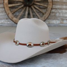 "This hat band is made with brown leather that is laced through silver oval conchos. It is adjustable in the back with a metal slide. Made in the USA 1 1/8\" x 7/8\" conchos Genuine leather *This product is for 1 single hat band. Hat not included." Cheap Brown Western Hat Bands, Brown Leather Hat, Western Brown, Hat Bands, Leather Hat, Metal Slide, Leather Hats, Stick Pins, Hat Band