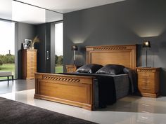 a large bed sitting in a bedroom next to a dresser and mirror on the wall