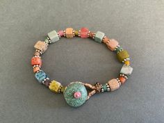 "This is an especially pretty pastel agate beaded bracelet. It is made with agates that are pastel colors including blue, green, pink, beige, and coral. There are small rondel beads in between the square beads. The  pastel bracelet has silver spaces and a turquoise button and beaded loop closure. You will choose to wear this special pastel bracelet often because the  soft colors are so appealing and is the perfect accessory for many occasions. 7 1/2\" long" Handmade Bohemian Beaded Bracelets In Pastel, Handmade Bohemian Pastel Beaded Bracelets, Handmade Pastel Bohemian Bracelets, Pastel Bracelet, Pastel Jewelry, Colorful Gemstones, Pastel Beads, Fun Bracelet, Square Beads