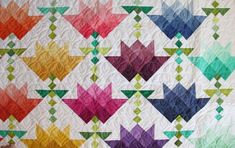 a colorful quilt with many different colors on the top and bottom, along with an arrow design