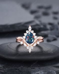 a blue and white diamond ring sitting on top of a rock