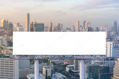 an empty billboard on top of a tall building with city in the background stock photo