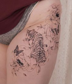 a woman with a tiger and flowers tattoo on her thigh