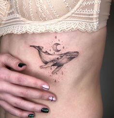 a woman's stomach with a whale tattoo on it