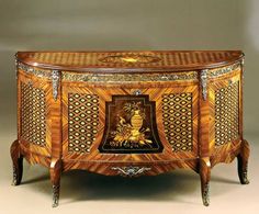 an ornately decorated wooden cabinet with intricate carvings on the front and sides, inlays