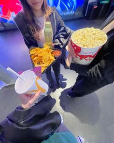 two girls are eating chips and watching tv