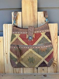 With gentle, alluring colors and tribal-inspired designs in its upcycled woven rug, this gorgeous bag will offer you great style and great function! It has plenty of space inside to carry all the essentials when you're on the go. The roomy interior features a separate zippered pocket. Durable leather shoulder strap is adjustable and detachable.  Approx. measurements are 16" x 15" x 4" Brown Tapestry Travel Bag, Multicolor Tapestry Bag For Daily Use, Multicolor Tapestry Bags For Everyday Use, Bohemian Tapestry Shoulder Bag For Everyday Use, Everyday Bohemian Tapestry Shoulder Bag, Daily Use Multicolor Tapestry Bags, Brown Tapestry Shoulder Bag For Daily Use, Bohemian Multicolor Tapestry Bags, Brown Tapestry Bags With Adjustable Strap