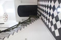 a black and white checkered floor in a house with a chandelier hanging from the ceiling