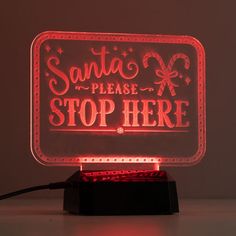 santa please stop here illuminated sign with red light up base and black stand on white background