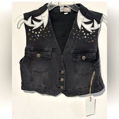 This Austin Landing Vest Is A Must-Have For Any Fashion-Forward Woman. The Black Denim And Leather Patches Give It A Edgy, Yet Chic Look That Is Perfect For Any Occasion. With A Button Closure And Studded Accents, This Vest Is Both Stylish And Functional. It Is Made Of A Cotton Blend Fabric And Lined With 100% Cotton, Making It Comfortable And Easy To Care For. This Vest Is Perfect For Summer, Fall, And Spring, And Is Available In A Women's Size L. The Biker Style And Cowboy/90s Theme Add A Touc Black Denim Vest With Pockets For Summer, Black Punk Vest For Spring, Spring Black Denim Vest, Edgy Streetwear Vest For Spring, Black Denim Casual Vest, Casual Black Denim Vest, Summer Black Denim Vest For Streetwear, Edgy Denim Vest For Fall Streetwear, Trendy Fitted Black Denim Vest