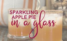 two glasses filled with liquid sitting on top of a table next to an orange pumpkin