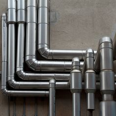 many metal pipes are lined up on the wall