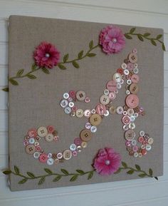 a wall hanging with buttons and flowers on it