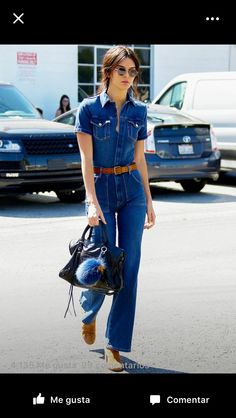 a woman walking down the street carrying a handbag