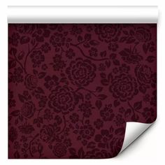 a red floral wallpaper with dark purple flowers on the bottom and white paper underneath it