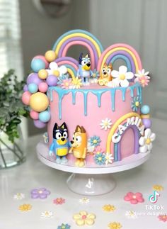 a cake decorated with cartoon characters and balloons